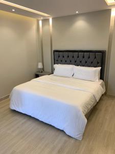 巴哈شاليه اوبل قاردن - OPAL GARDENS的卧室配有一张带白色床单和枕头的大床。