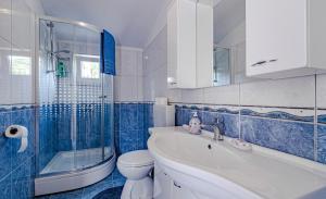 科尔丘拉Apartments Pada的蓝色和白色的浴室设有水槽和卫生间