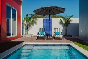 Santa CruzTrankilidad Apartments的一个带两把椅子和遮阳伞的游泳池