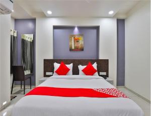 德瓦尔卡The Sky Comfort Hotel Parth Inn的一间卧室配有一张带红色枕头的大床