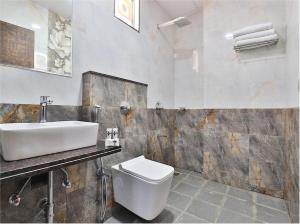 德瓦尔卡The Sky Comfort Hotel Parth Inn的浴室配有白色卫生间和盥洗盆。