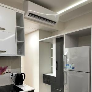 巴统Angel Apartment in Porta Batumi的厨房配有白色橱柜和冰箱。