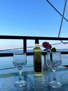 哈拉奇Porto Haraki Studios的一张桌子上摆放着一瓶葡萄酒和两杯酒杯