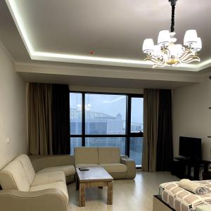巴统Angel Apartment in Porta Batumi的带沙发和大窗户的客厅