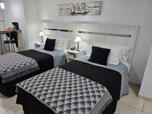 圣达菲Diseño y confort Monoambiente a pasos del Río!的酒店客房带两张黑白床单