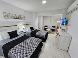 圣达菲Diseño y confort Monoambiente a pasos del Río!的酒店客房设有两张床和一台平面电视。