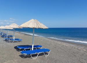 依拉佩特拉Long Beach Resort的海滩上一排蓝色的椅子和遮阳伞