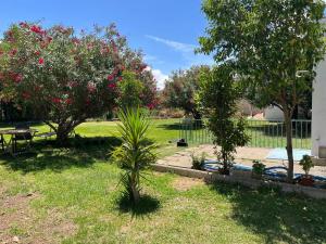 韦托维加VILLA HUETOR , Magnifico chalet con piscina privada的一个带树木和桌子的花园以及围栏