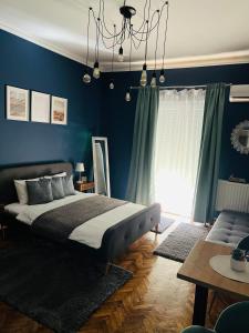萨图马雷Bulevard Apartments的一间卧室设有一张床和蓝色的墙壁