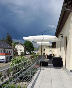 温特里希Gästehaus Föhr的庭院配有白色遮阳伞和桌椅。