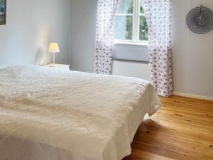 EkebyHoliday home MUNSö的一间卧室设有一张床和一个窗口
