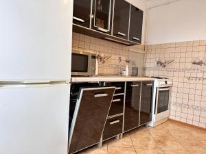 格利维采Apartament Dąbrowskiego - Gliwice的厨房配有棕色橱柜和白色冰箱