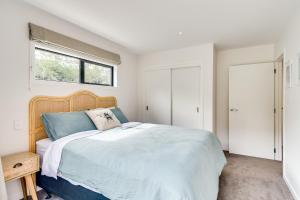 北哈夫洛克River Range Cottage - Havelock North Holiday Home的一间卧室设有一张大床和一个窗户。