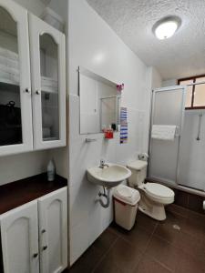 基多Apartamento 32 Juana de Arco的白色的浴室设有卫生间和水槽。