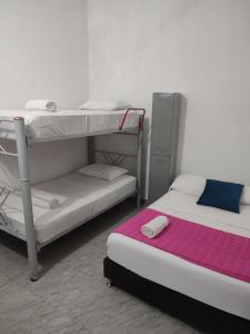 卡塔赫纳1811旅馆的一间卧室设有两张双层床和紫色毯子