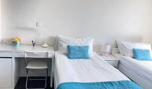 里斯本YingYing Apartamento with a free parking space的一间卧室配有一张床和一张带蓝色枕头的书桌
