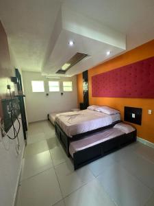 阿卡普尔科Isla cuba的一间卧室设有两张床和红色的墙壁
