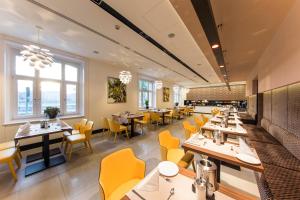 布达佩斯布达佩斯维多利亚精品酒店的用餐室配有桌子和黄色椅子