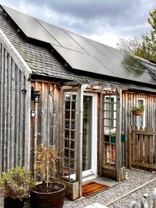 斯佩河畔格兰敦Courtyard Bothy的木制温室,设有窗户和屋顶