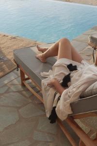Glinado NaxosVouno Luxury Villas的躺在游泳池旁床边的女人