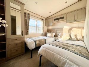 斯凯格内斯Stunning Caravan With Full Lake View At Southview Holiday Park Ref 33004ml的一间带两张床的卧室和一台电视