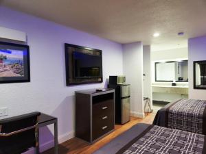 汤博尔Express Inn Tomball的配有一张床和一台平面电视的酒店客房