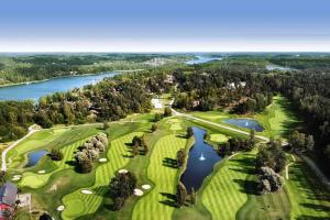 斯德哥尔摩Modern, mysig & exklusiv villa i Skärgården #1的享有高尔夫球场和湖泊的空中景致