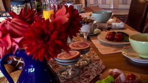 韦斯特波特Birds Ferry Lodge的一张桌子,上面有蓝色花瓶,上面有红色的花
