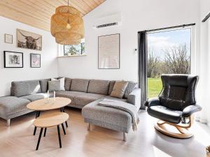 格莱斯堡10 person holiday home in Glesborg的客厅配有沙发、椅子和桌子