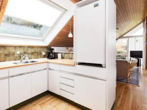 博托比4 person holiday home in Idestrup的厨房配有白色橱柜和窗户。