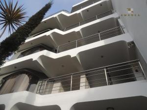 利马San Miguel Awanka Hotel的一座白色的建筑,前面有棕榈树