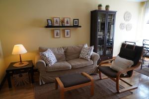 卢安科ALMAR, Apartamento en Luanco.的客厅配有沙发和两把椅子