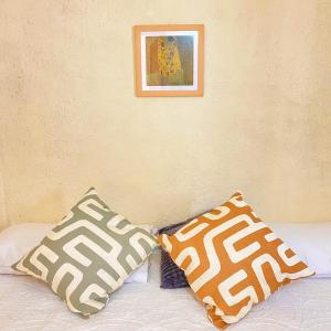 伊斯塔帕Casa ALOA Ixtapa的一张带两个枕头的床和一张墙上的照片