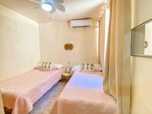 伊斯塔帕Casa ALOA Ixtapa的带吊扇的客房内的两张单人床