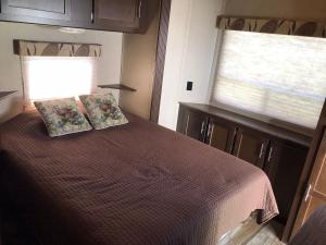 MiddletonOrchard Queen Motel & Rv Park的一间卧室配有带两个枕头的床和窗户