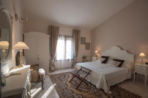 圣朱利亚诺-泰尔梅卡萨勒莱斯旅馆的一间卧室配有一张床、一把椅子和一张桌子