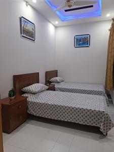 伊斯兰堡Islamabad Comfort Home的一间卧室设有两张床和蓝色的天花板
