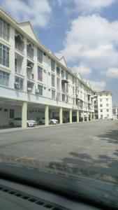 哥打巴鲁Sis Homestay Wakaf Che Yeh, Kota Bharu的一座白色的大建筑,汽车停在停车场