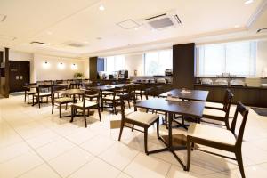 磐城Sunrise Inn Iwaki的用餐室设有桌椅和窗户。