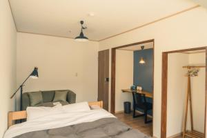 松本Raicho Onsen Inn的一间卧室配有一张床、一把椅子和一张书桌