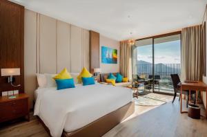 芽庄Homie Panorama Beachfront Residences Nha Trang的一间带大床的卧室和一间客厅
