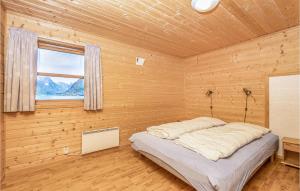 菲耶兰3 Bedroom Amazing Home In Fjrland的木制客房内的一间卧室,配有一张床