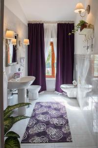 圣朱利亚诺-泰尔梅卡萨勒莱斯旅馆的浴室设有2个水槽、2个卫生间和紫色窗帘