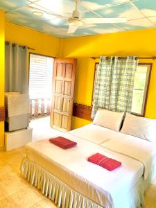 涛岛苏梅岛热带度假酒店的一间卧室配有一张带两个红色毛巾的床