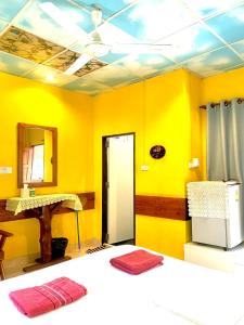 涛岛苏梅岛热带度假酒店的黄色客房,配有床和镜子