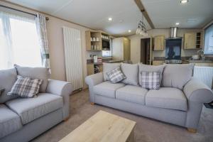 斯凯格内斯Beautiful 6 Berth Caravan With Decking At Southview Holiday Park Ref 33024o的一间带两张沙发的客厅和一间厨房