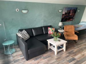 Den IlpAmsterdam Countryside met Airco , luxe keuken en een geweldig uitzicht, Immer besser!的客厅配有黑色沙发和桌子