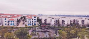 下龙湾Ha Long Essence Premium Hotel的城市的空中景观,房屋和河流