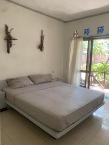 吉利特拉旺安Bintang Guesthouse的卧室内的一张大床,设有窗户