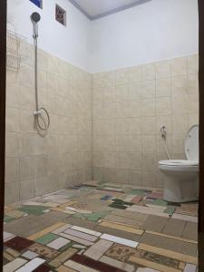 吉利特拉旺安Bintang Guesthouse的一间带卫生间的浴室,铺有瓷砖地板。